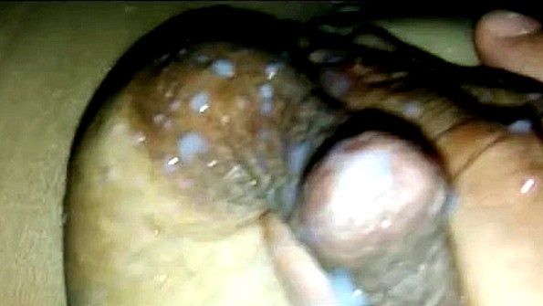 Выдавливает молоко из сосков пальцами крупным планом